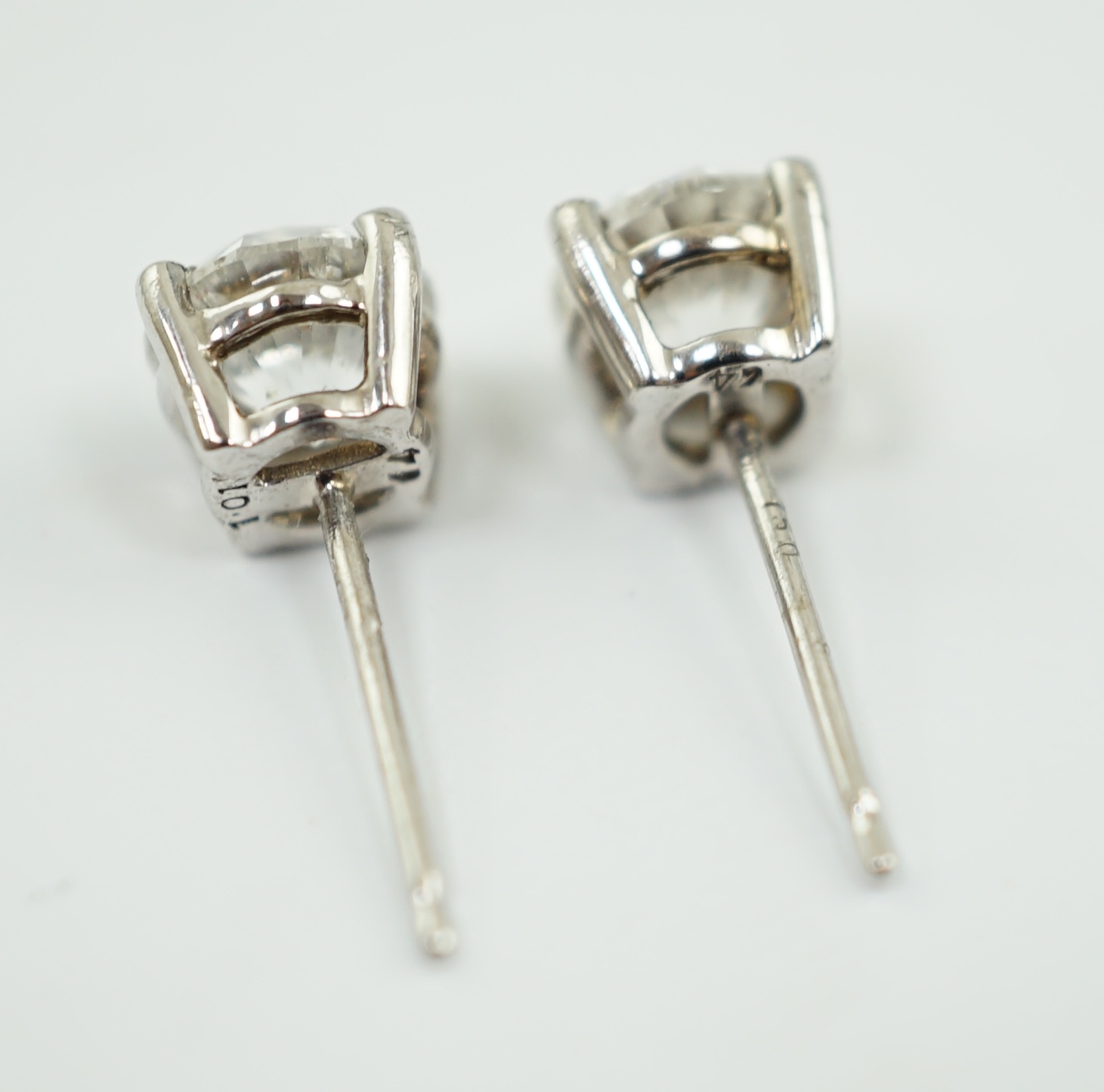 A modern pair of 18k white gold and round brilliant cut solitaire diamond set ear studs